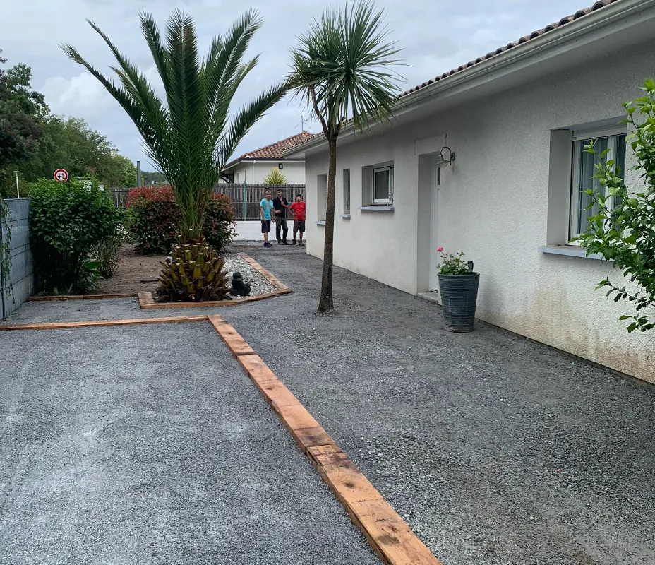 Allée et cour aménagées en gravier avec bordure bois