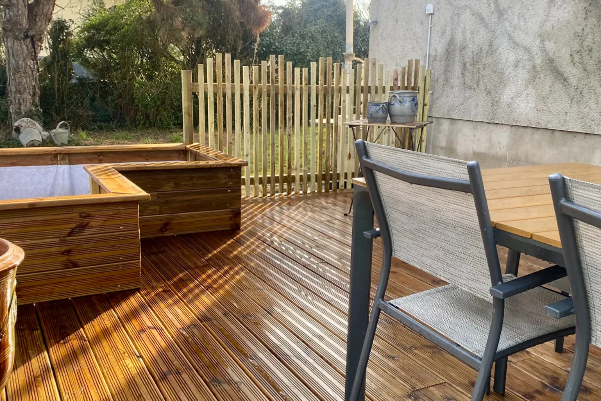 Terrasse en bois avec jardinières et salon de jardin